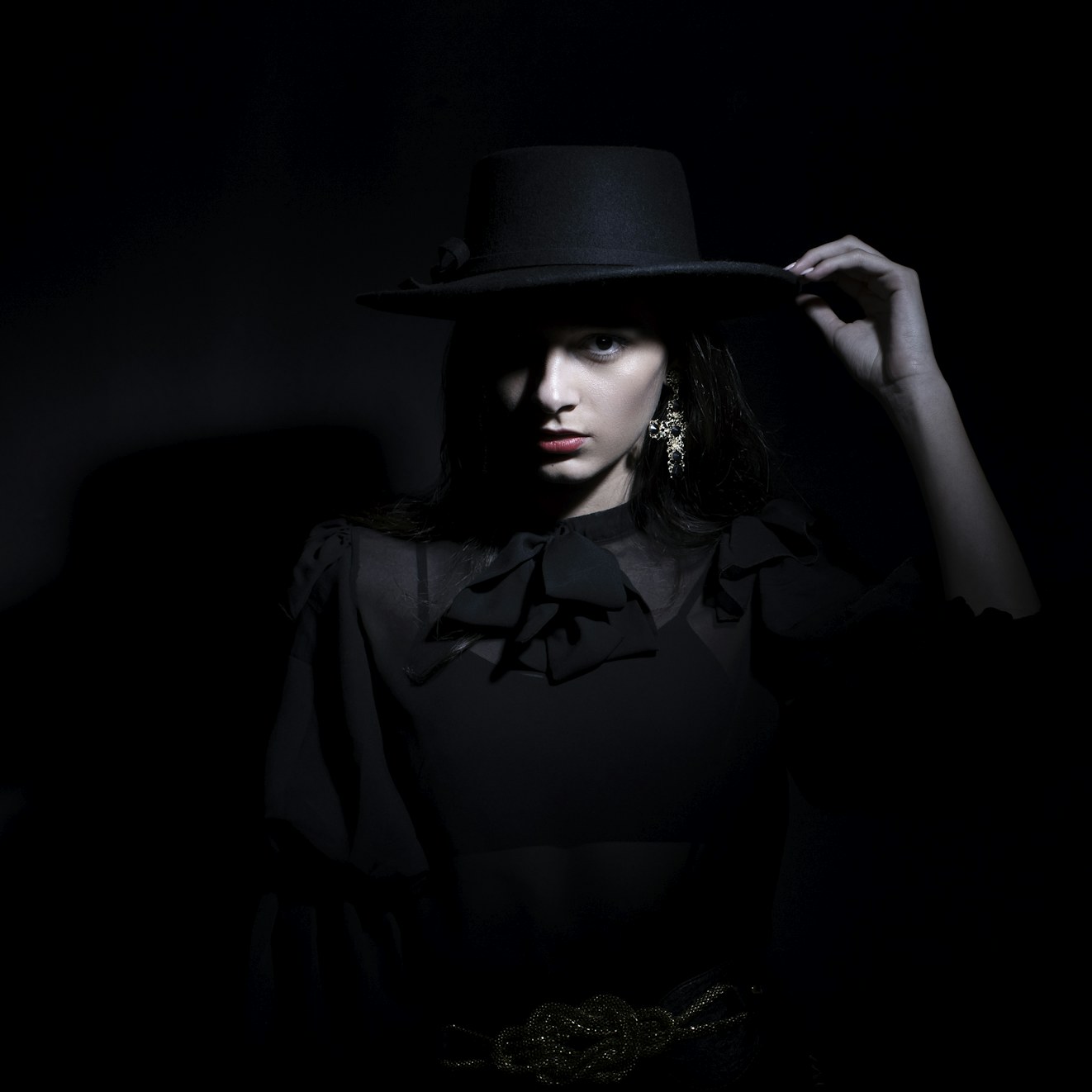 Woman in black wearing a black hat, editorial portrait